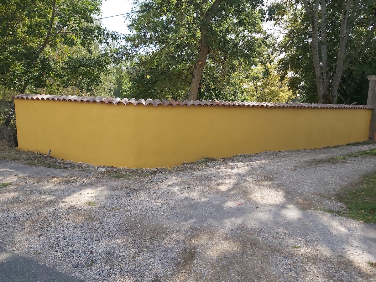 Réalisation d’Altay Maçonnerie : mur de clôture enduit en jaune, couvert de tuiles