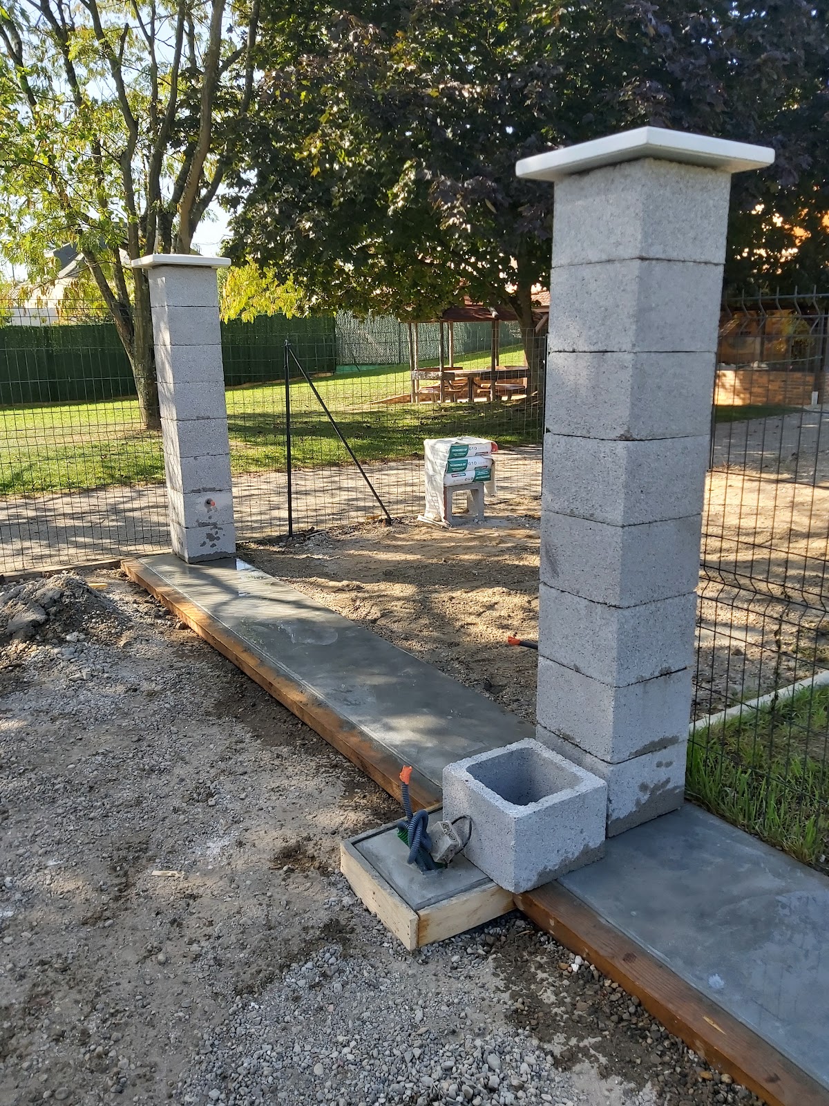 Chantier d’Altay Maçonnerie : piliers de portail en blocs de béton sur une semelle coulée